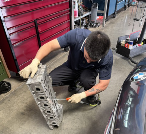 mechanic working with car part at shop